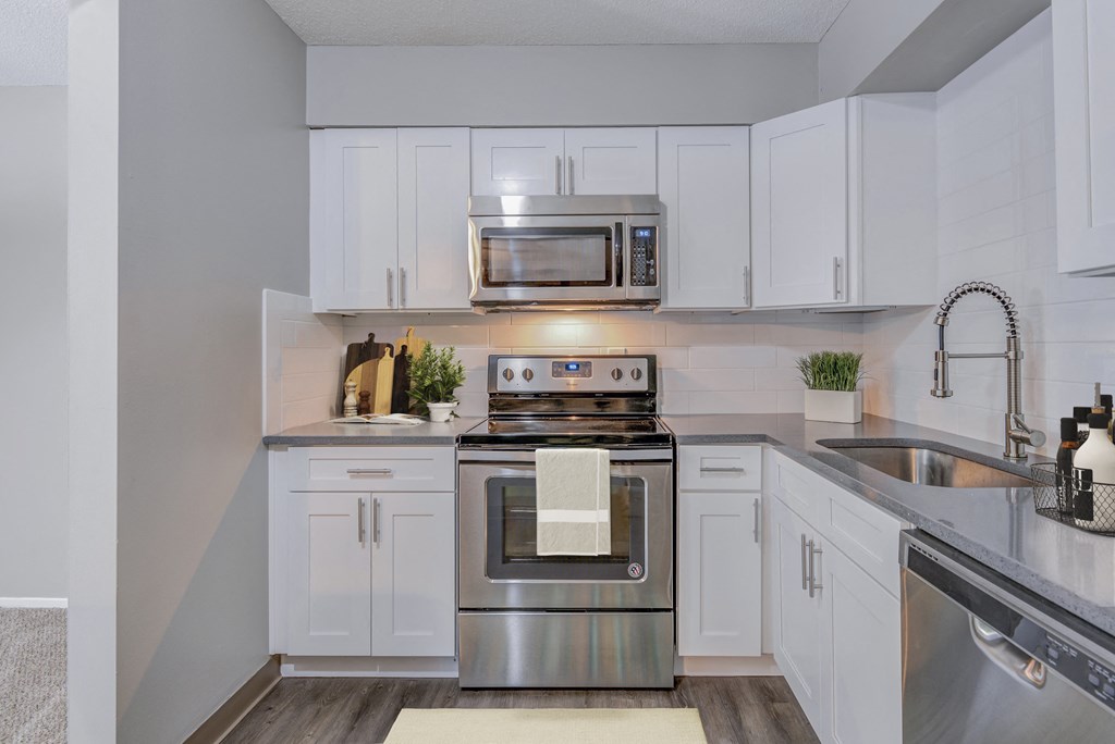 a kitchen with stainless steel appliances and white cabinets