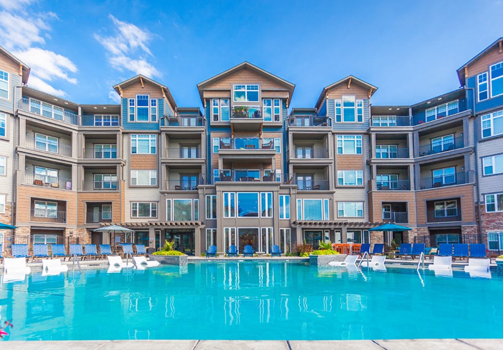 a large swimming pool in front of an apartment building