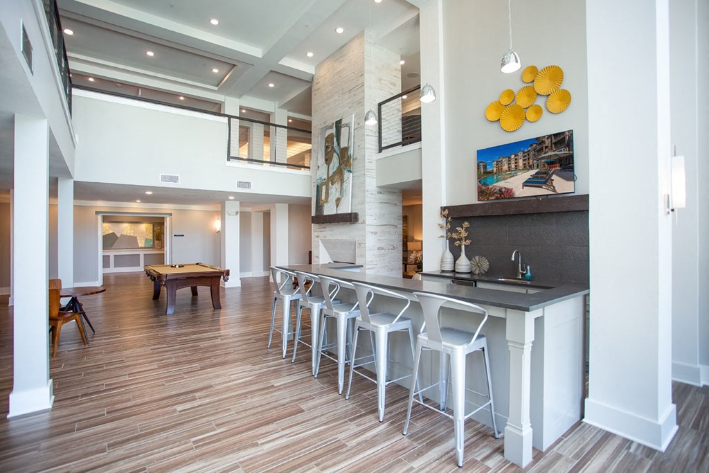 a bar with stools in a living room with a table