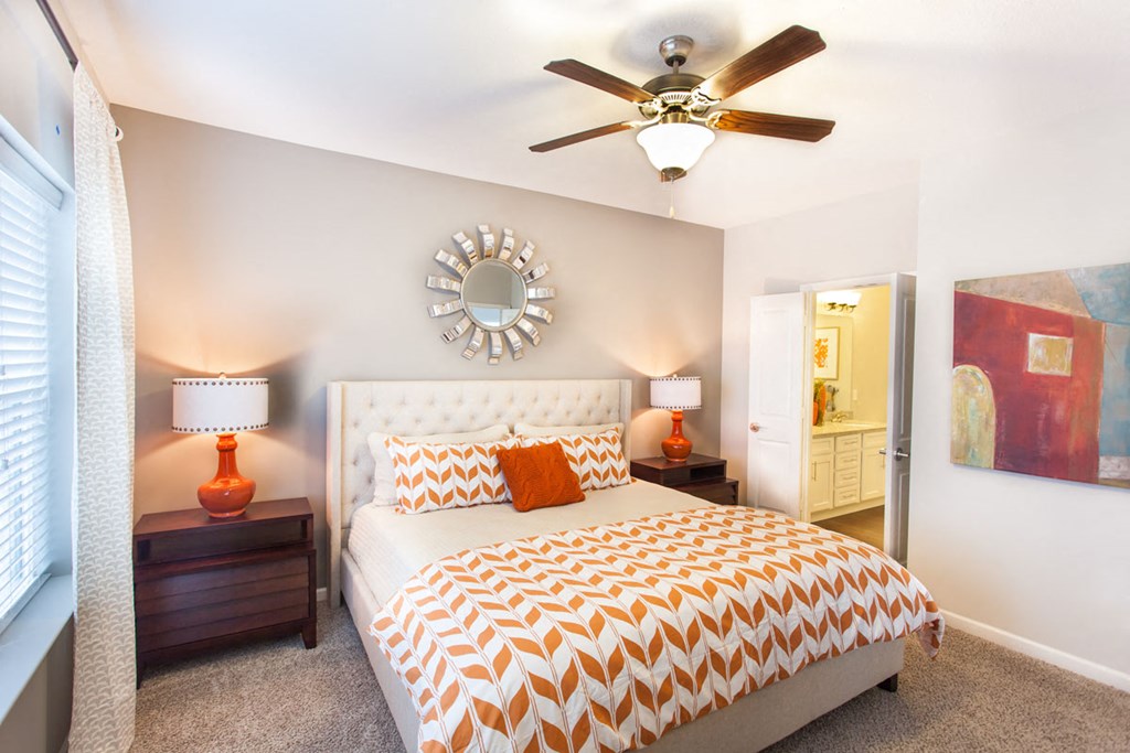 a bedroom with a bed and a ceiling fan