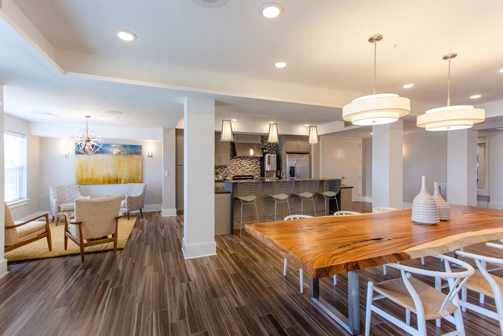 a dining room and kitchen with a wooden table and chairs