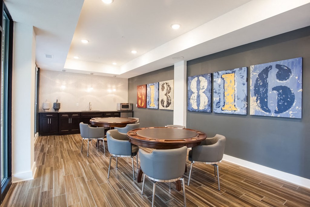 a dining room with a table and chairs and paintings on the wall