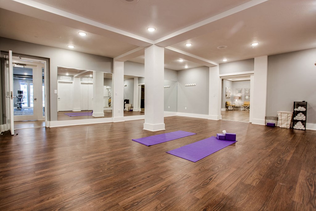 a spacious yoga room with purple yoga mats