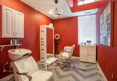 Hair salon with red walls and a chandelier
