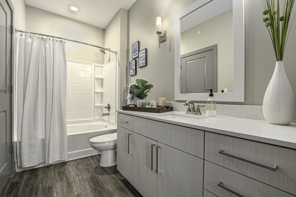 a bathroom with white cabinets and a white shower curtain