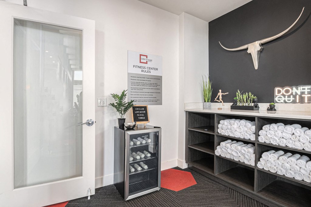 a room with a rack of towels and a deer skull on the wall