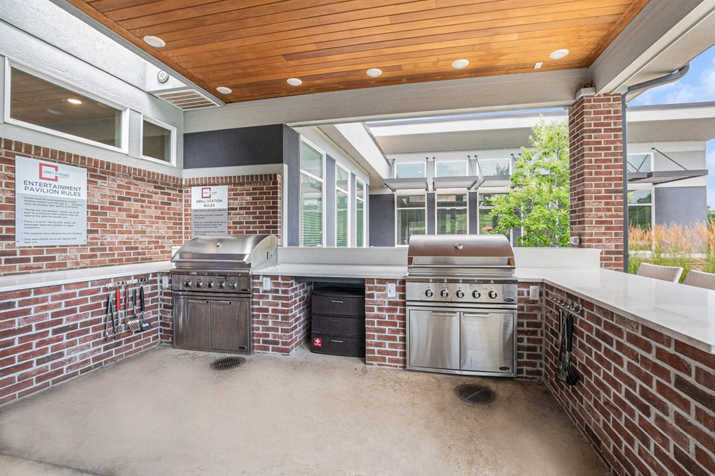 a large outdoor kitchen with stainless steel appliances and a wooden ceiling