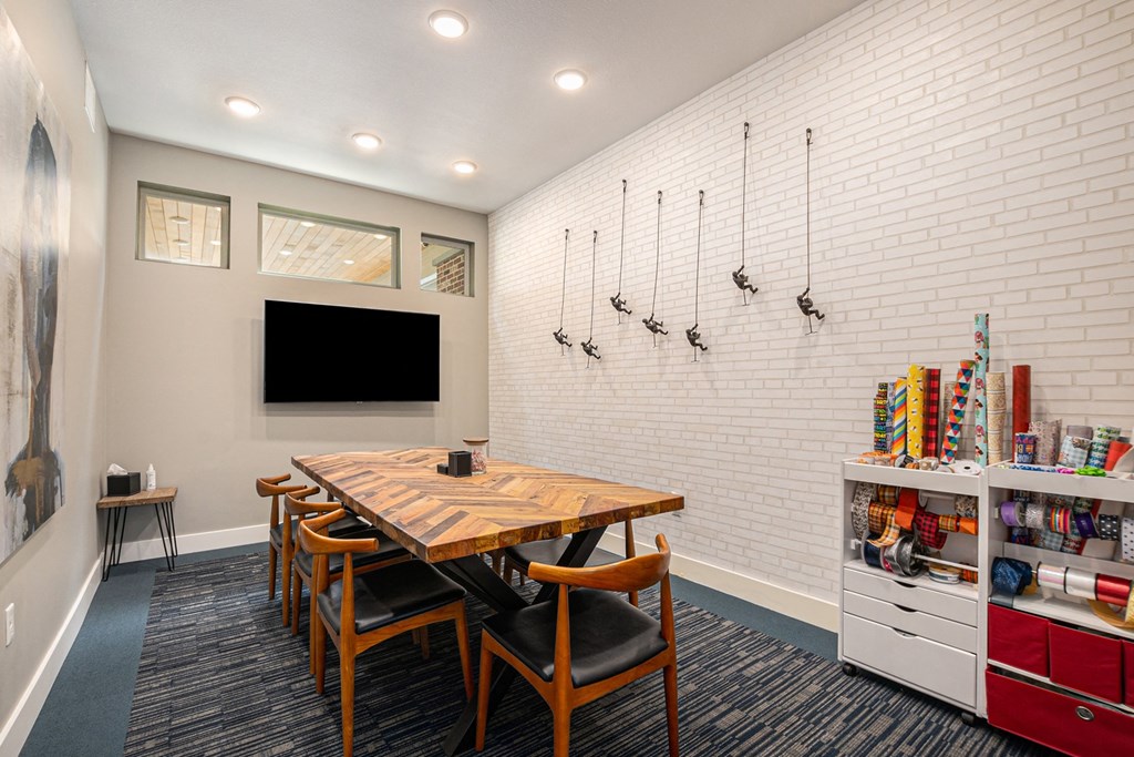 a room with a table and chairs and a tv on the wall