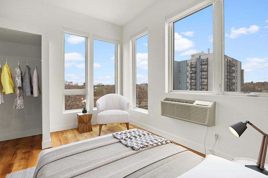 a bedroom with a bed and three windows