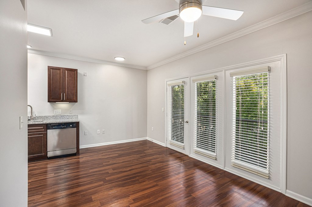a kitchen and living room with hardwood floors and a ceiling fan