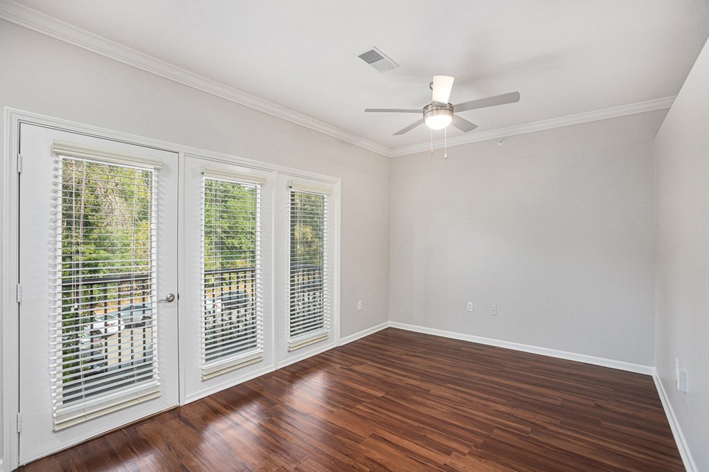 a bedroom with hardwood floors and a ceiling fan