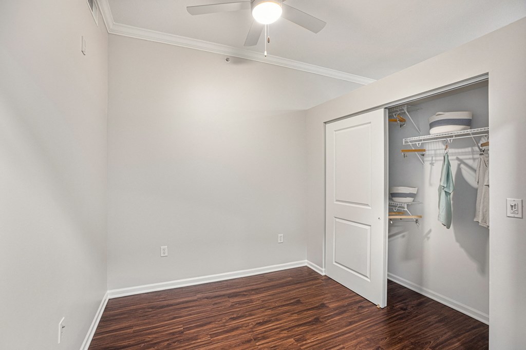 a bedroom with a closet and a ceiling fan