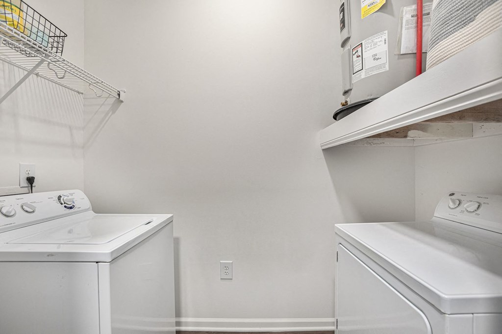 a laundry room with two washers and a dryer