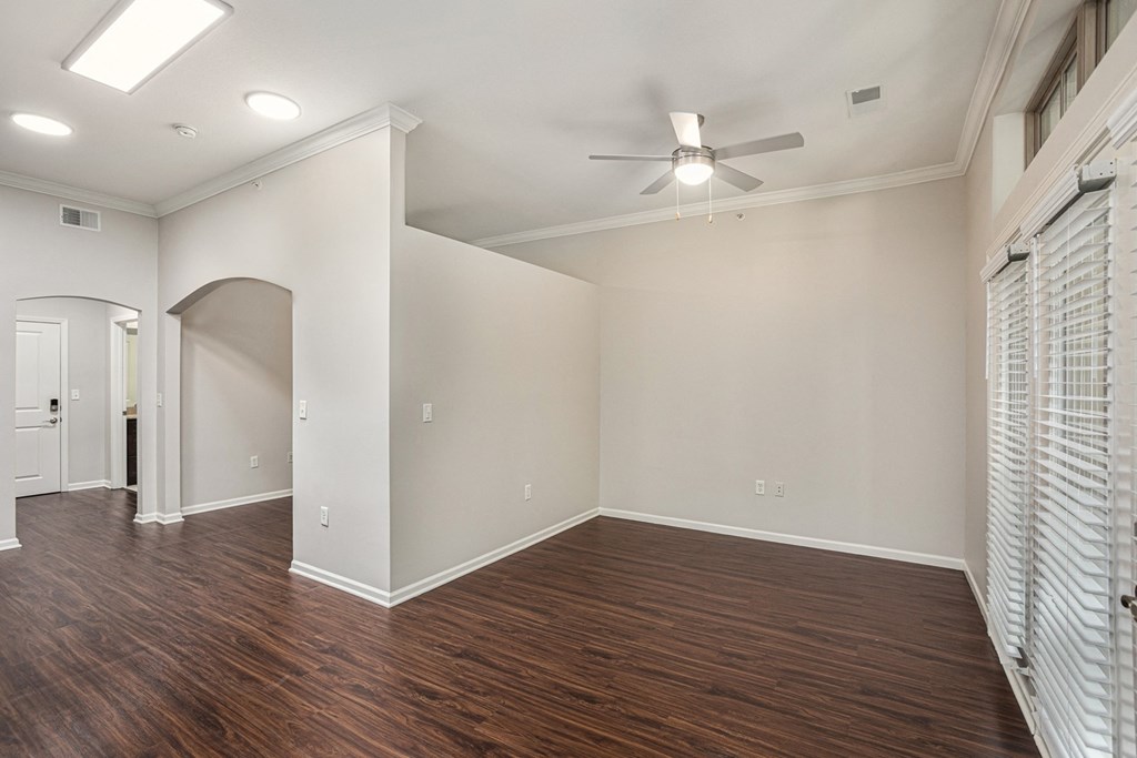 a living room with hardwood floors and a ceiling fan