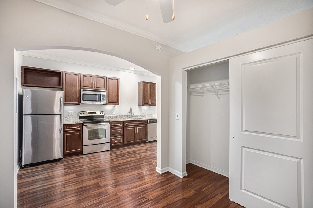 a kitchen with wood flooring and stainless steel appliances