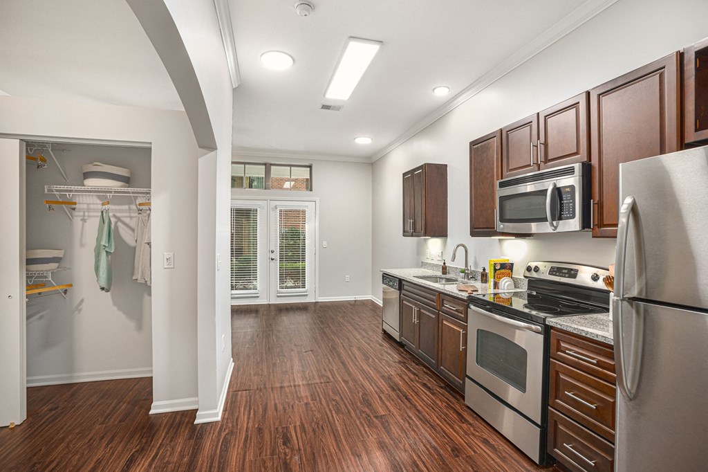 a kitchen with dark wood cabinets and stainless steel appliances