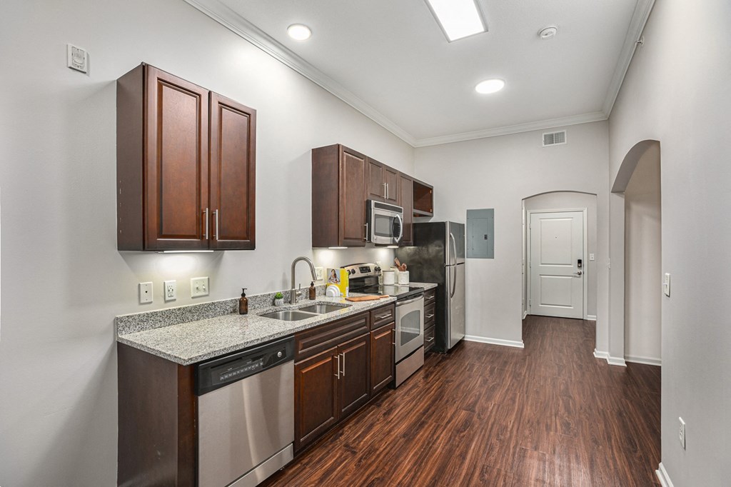 a kitchen with dark wood cabinets and granite countertops