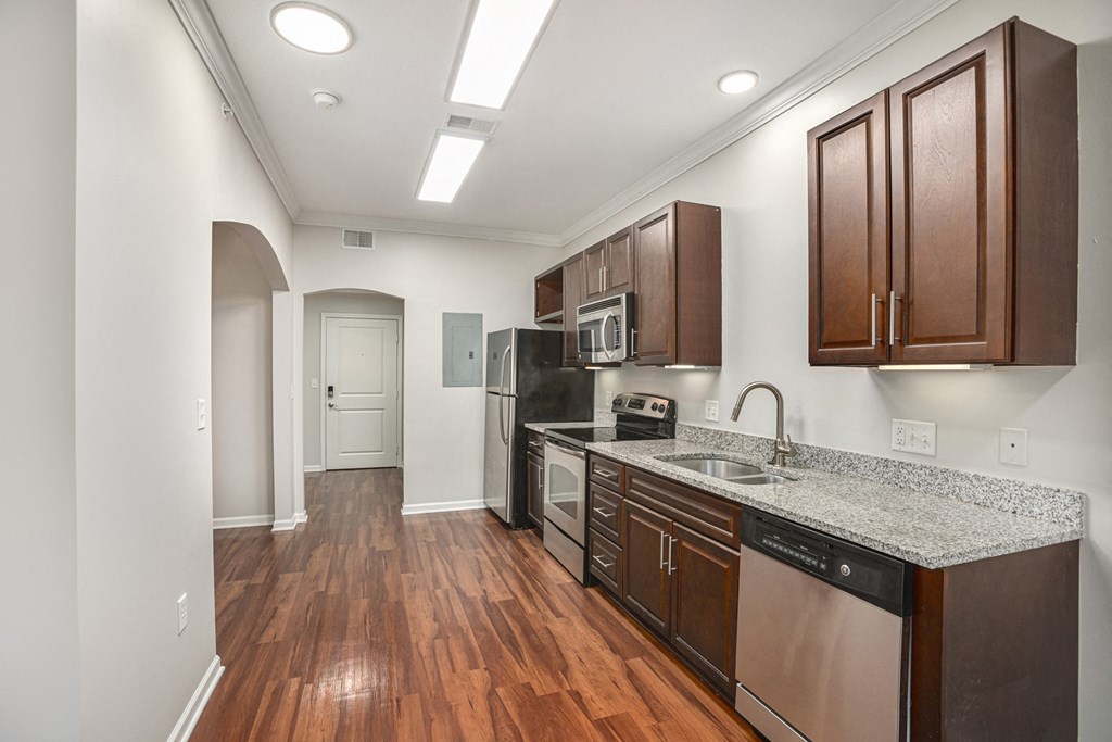 a kitchen with dark wood cabinets and granite countertops