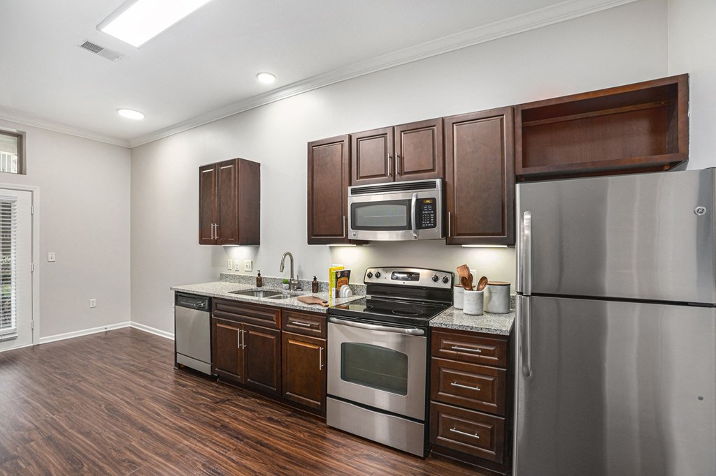 a kitchen with dark wood cabinets and stainless steel appliances