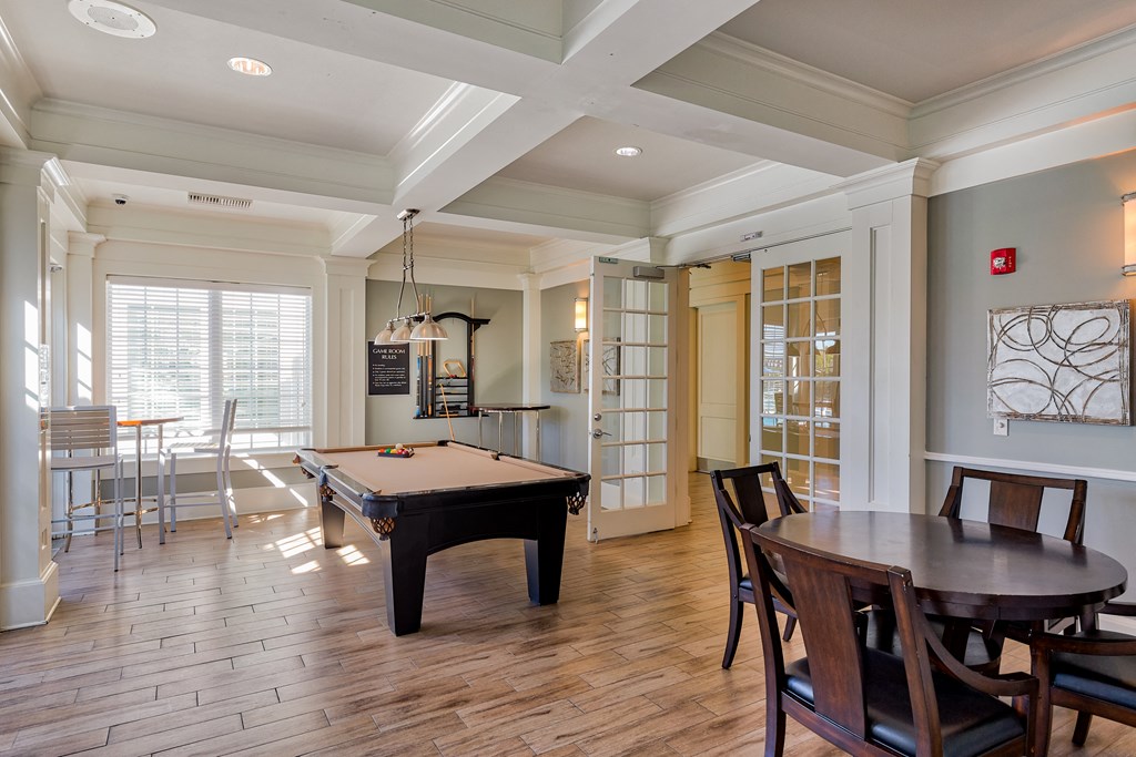 a game room with a pool table and a dining table
