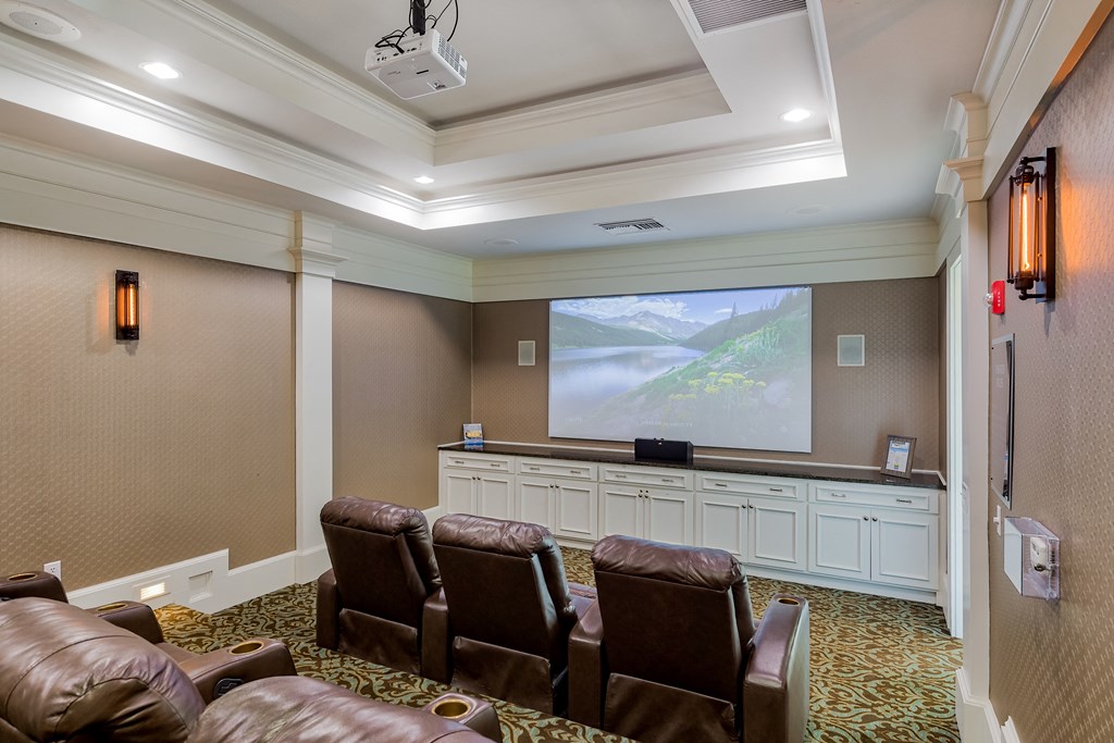 a large screening room with leather chairs and a projector screen