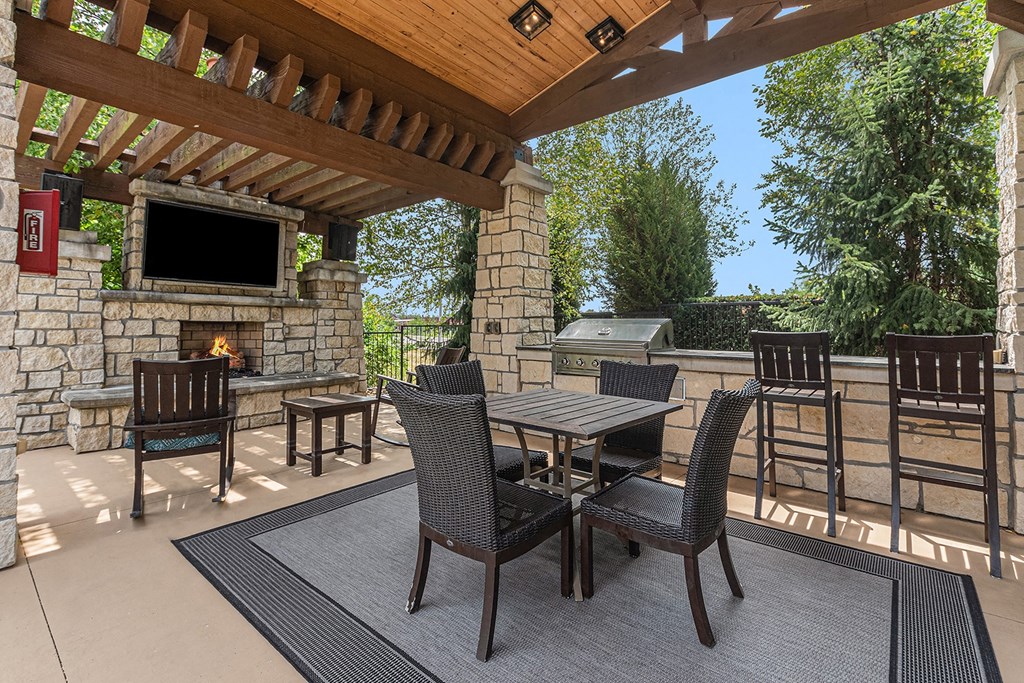 a covered patio with a fireplace and tv