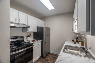 a kitchen with white cabinets and stainless steel appliances