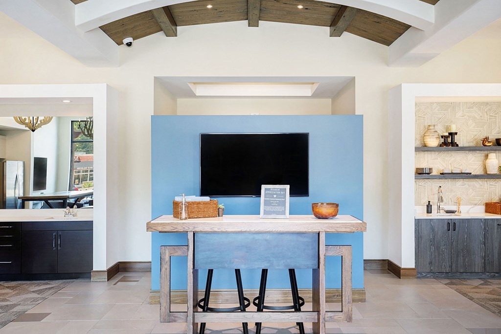 a kitchen with a blue wall and a table with three stools