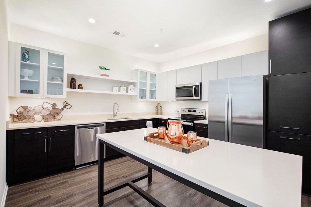 a kitchen with black appliances and a white table
