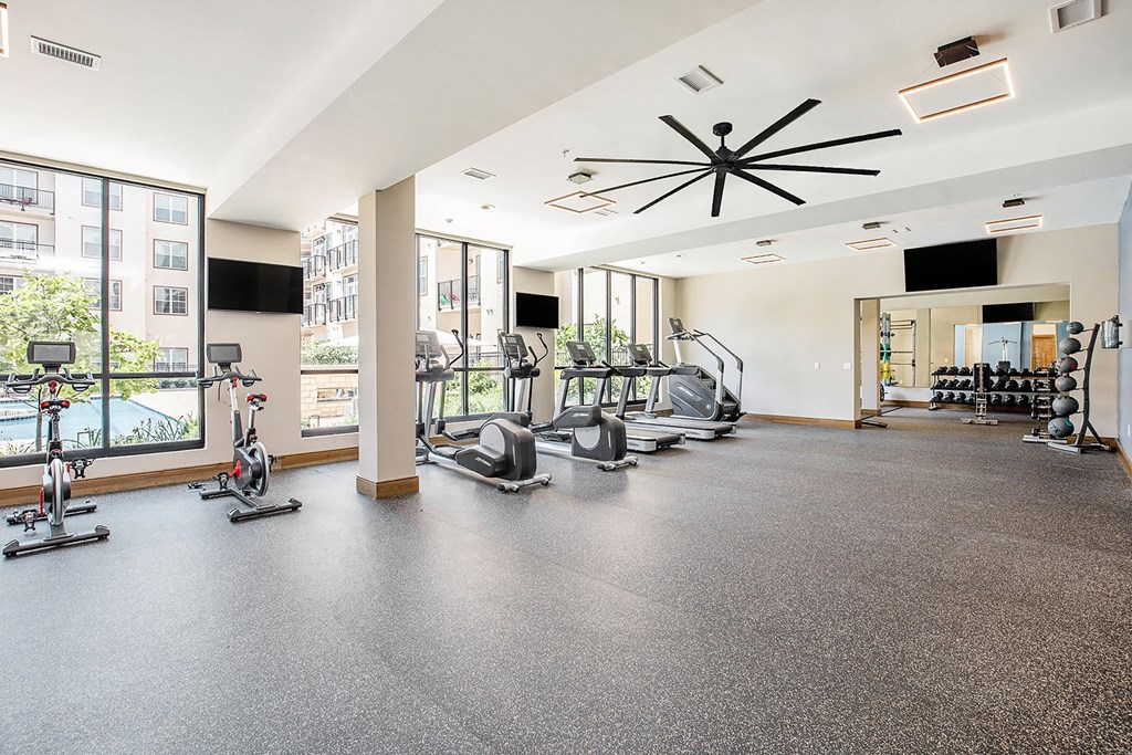 the gym with treadmills and weights at the grove apartments