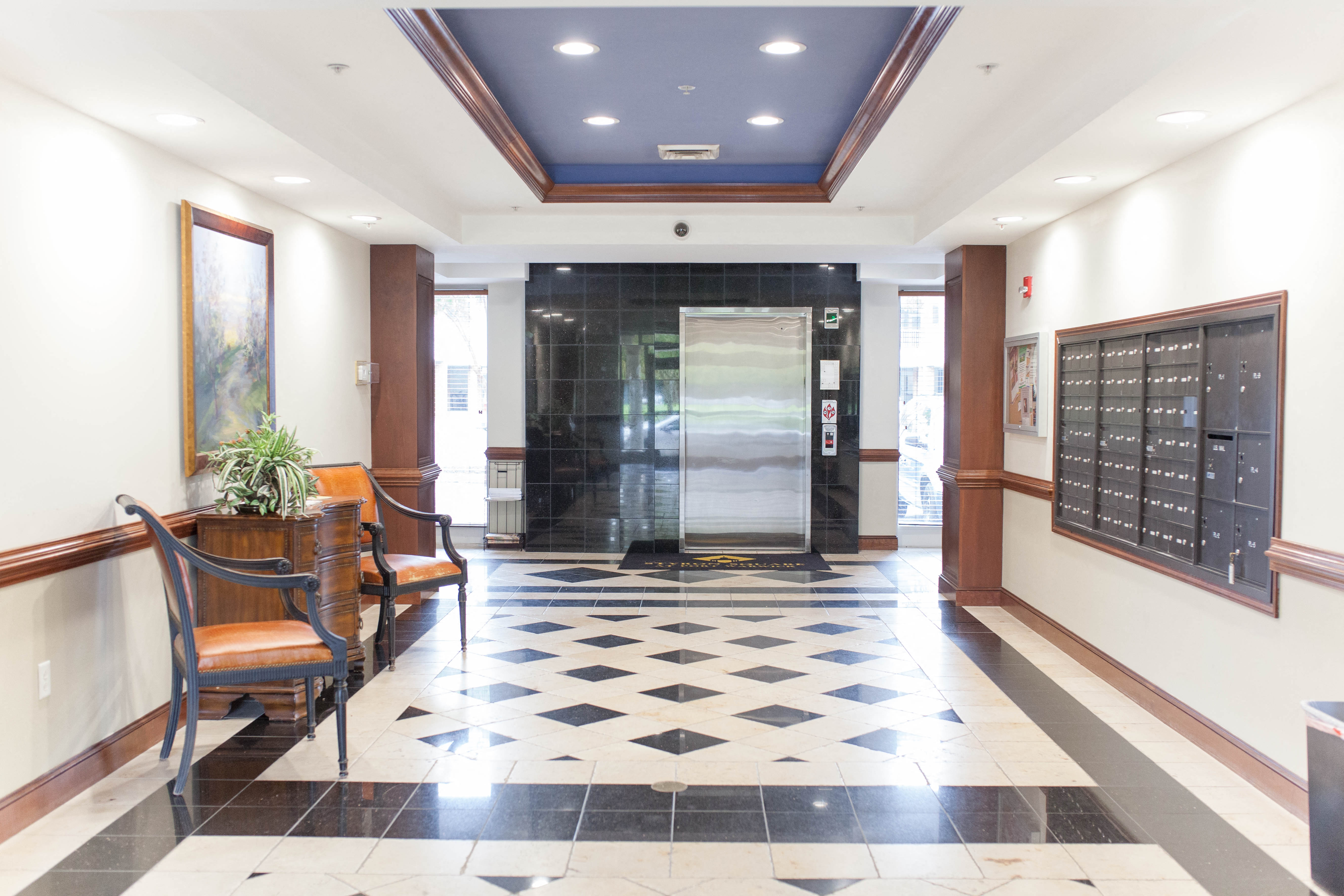 a lobby with a black and white checkered floor and a front door