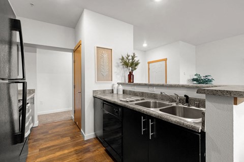 A kitchen with black cabinets and a white counter.