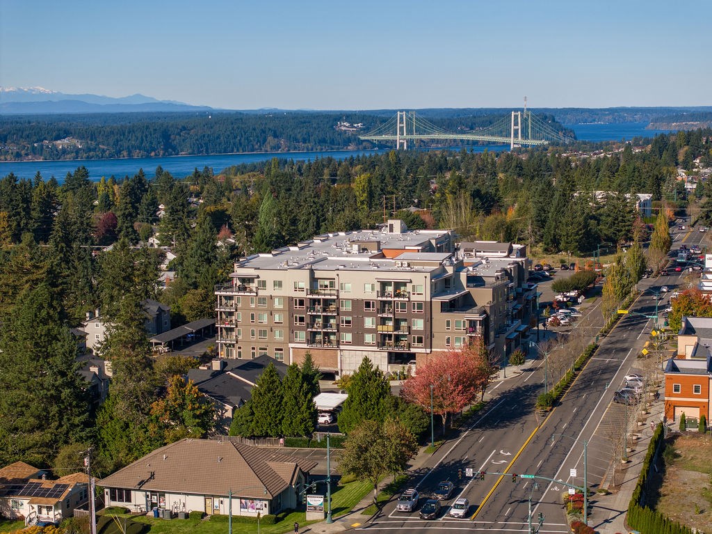 an aerial view of a building with a bridge in the background