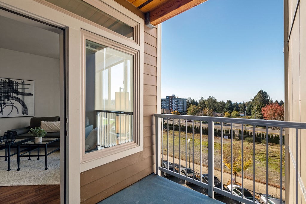 a balcony with a view of a yard and a glass door