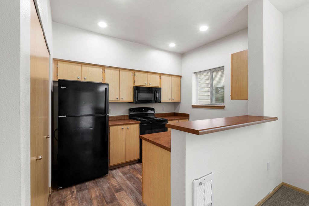 Apartments in Milton for Rent - Sundance - Kitchen with Tall Bar Island, Black Kitchen Appliances, and Natural Lighting