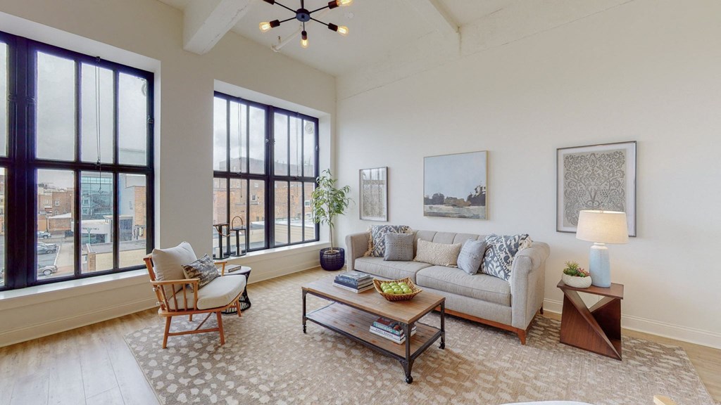 a living room with a couch and a coffee table and large windows