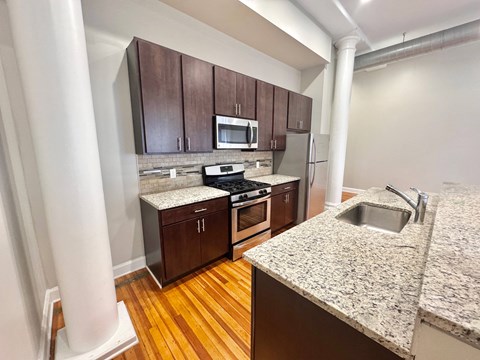 a kitchen with wood flooring and granite counter tops and