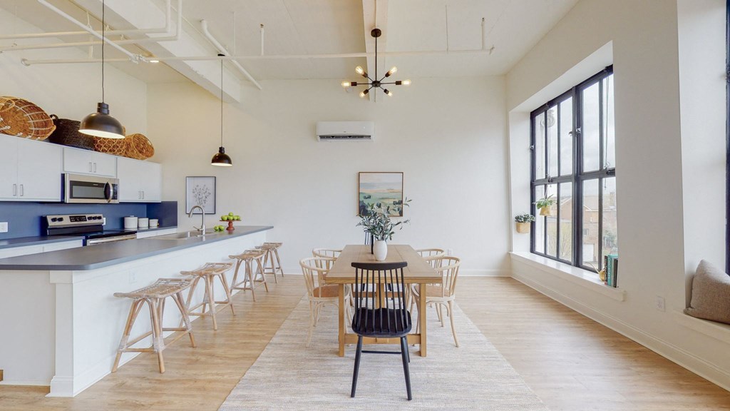 a dining room and kitchen area with a table and chairs and a large window