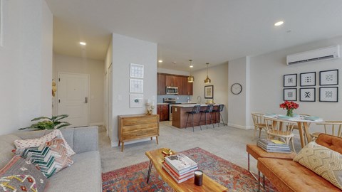 a living room with a couch and a table and a kitchen