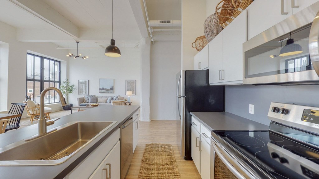 an open kitchen with stainless steel appliances and white cabinets
