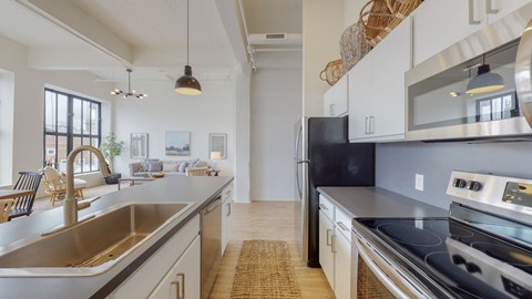 an open kitchen with stainless steel appliances and white cabinets