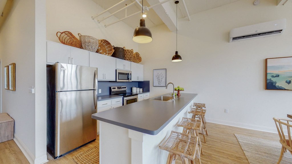 a kitchen with stainless steel appliances and a bar with stools