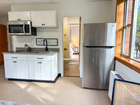A kitchen with a refrigerator and cabinets.