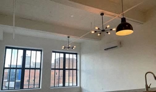 a white room with two windows and a black light fixture