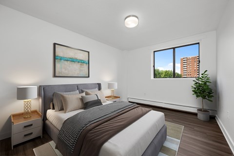 A bedroom with a large bed and a painting on the wall.