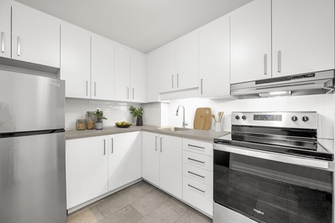 A modern kitchen with white cabinets and stainless steel appliances.