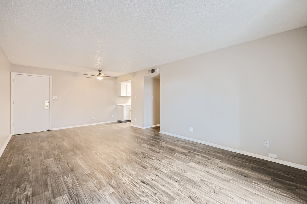 an empty living room with wood flooring and white walls