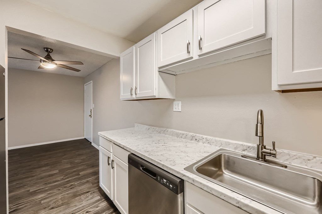 the kitchen of a home with white cabinets and a stainless steel sink