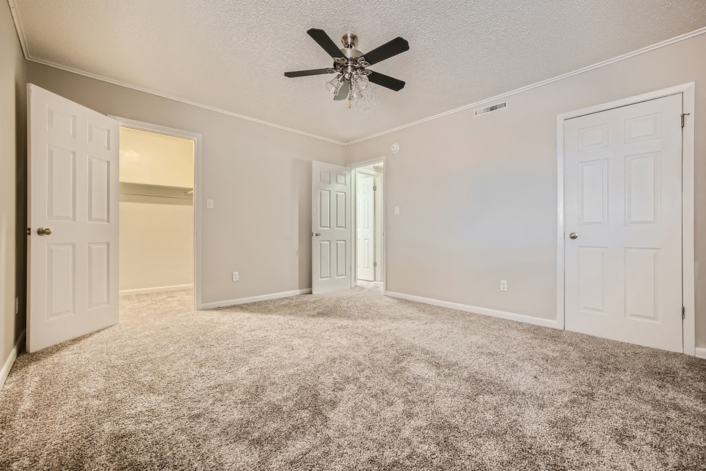 Bedroom with spacious closet and ceiling fan