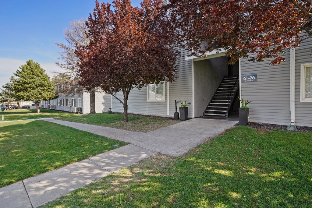 a sidewalk in front of a building with stairs